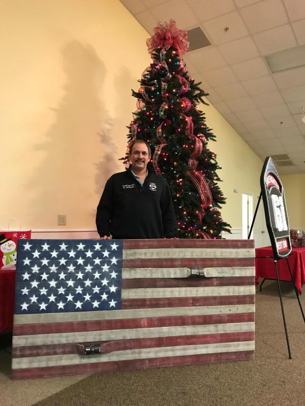 Captain Bill Jackson presenting the Flag that he made out of retired fire hose